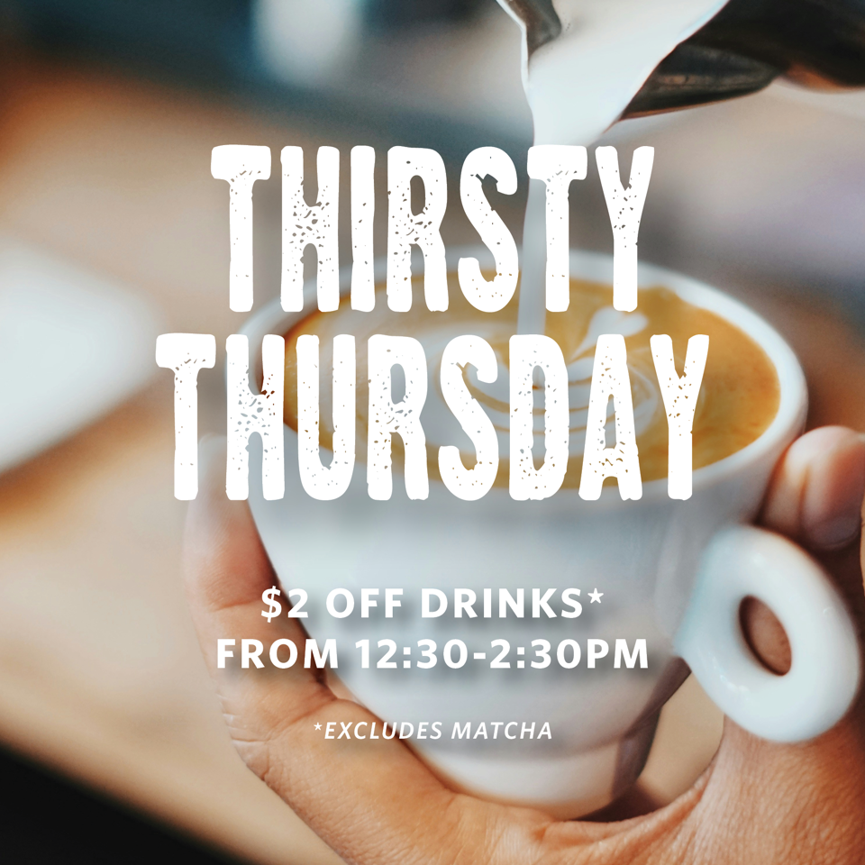 Close-up of a hand holding a latte while milk is poured, with text promoting $2 off drinks from 12:30–2:30 PM.