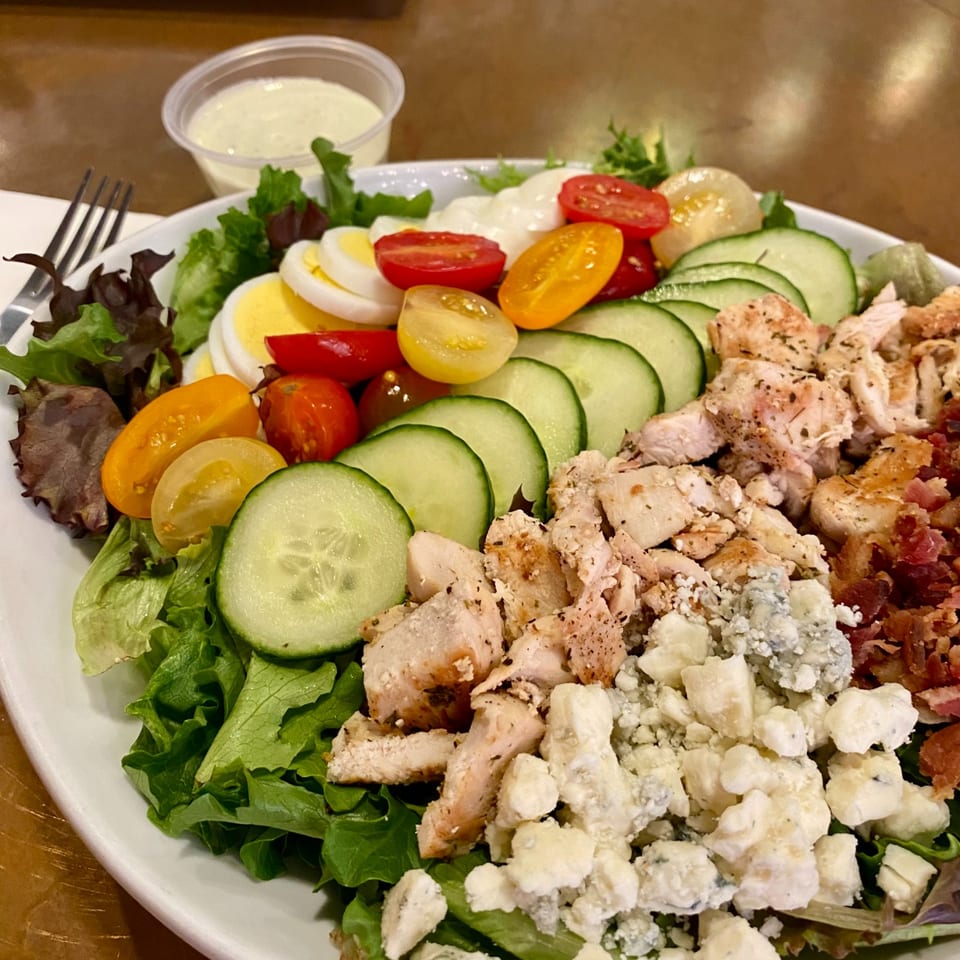 Cobb salad with chicken, cucumber, tomatoes, egg, and cheese.